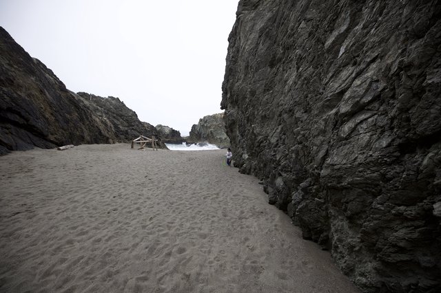 Child Dwarfed by Towering Sea Cliffs at Hidden Cove