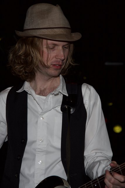 Beck Strums His Guitar in Fedora and Vest
