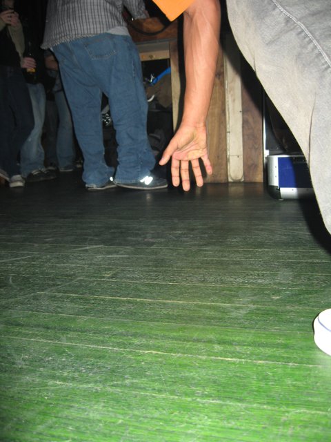 Grey Shirted Man on Plywood Floor