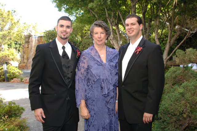 Three people in formal wear posing for a picture