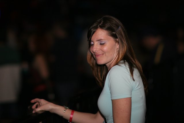 Woman Smiling Softly at Dimly Lit Nighttime Event