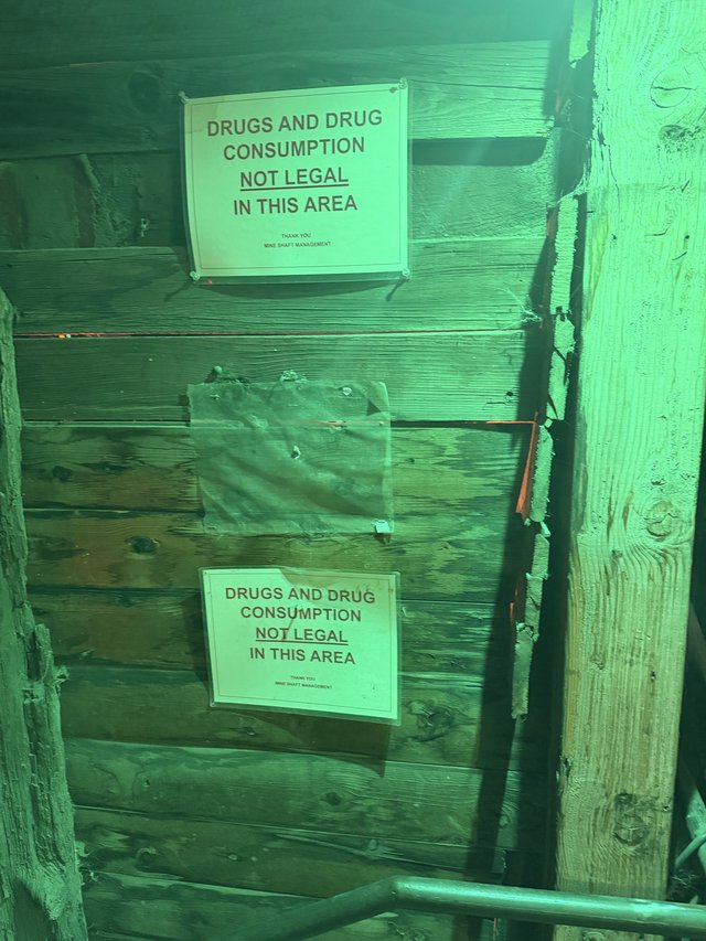 Drug Warning Signs in Green-Lit Mine Alley