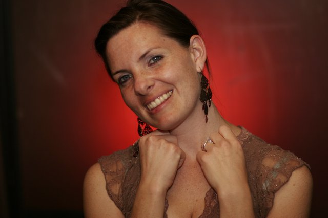 Smiling Woman in Lace Dress Against Red Background