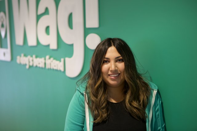 Smiling Woman in Front of Wag Logo