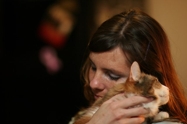 Tender Moment: Woman Embracing Her Calico Cat