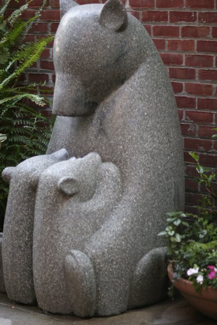 Stone Bear Statue in a Lush Garden