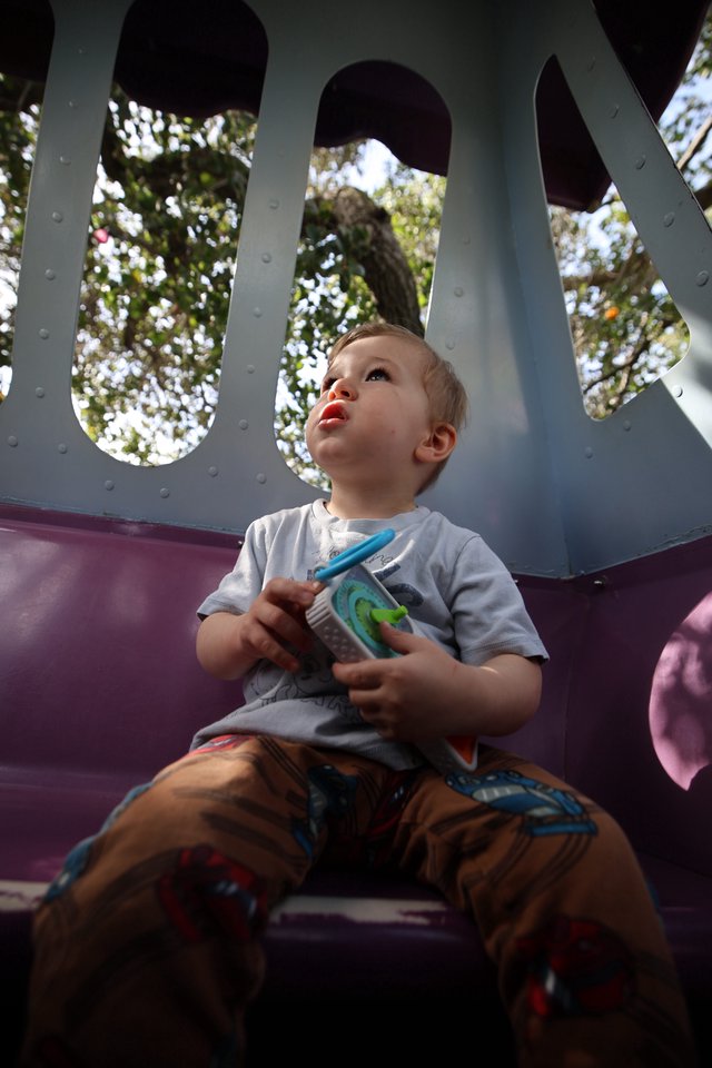 Young Child's Wonder on Playground Slide