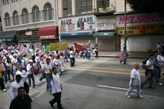 A Crowd Marching Down a Vibrant Urban Street