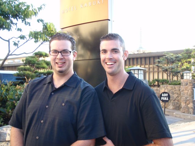 Two Men in Black Shirts Pose for a Portrait