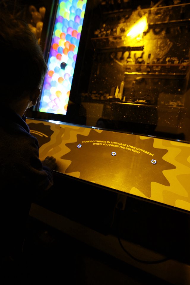 Child Exploring Interactive Museum Display at Night
