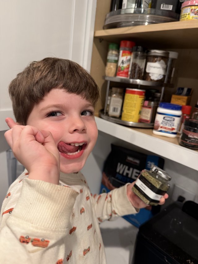 Young Boy Enjoys Snack Time in Kitchen Pantry