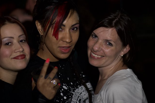 Three Women Posing Together at Nightclub Party