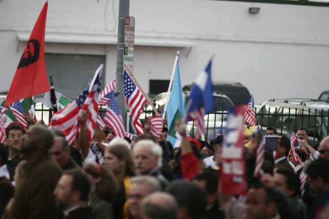 American and Mexican Flags Held High by Crowd