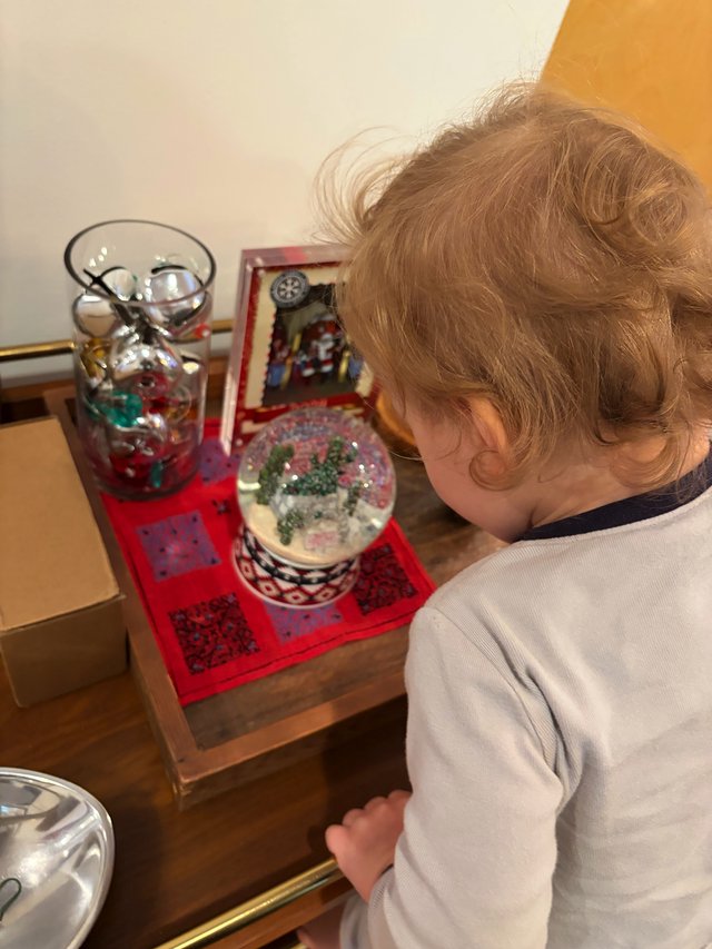 Young Child Discovering Christmas Snow Globe Wonders