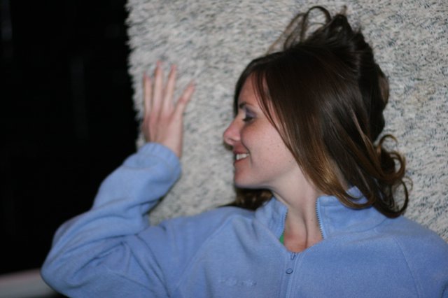 Laughing Woman Leans Against Textured Wall