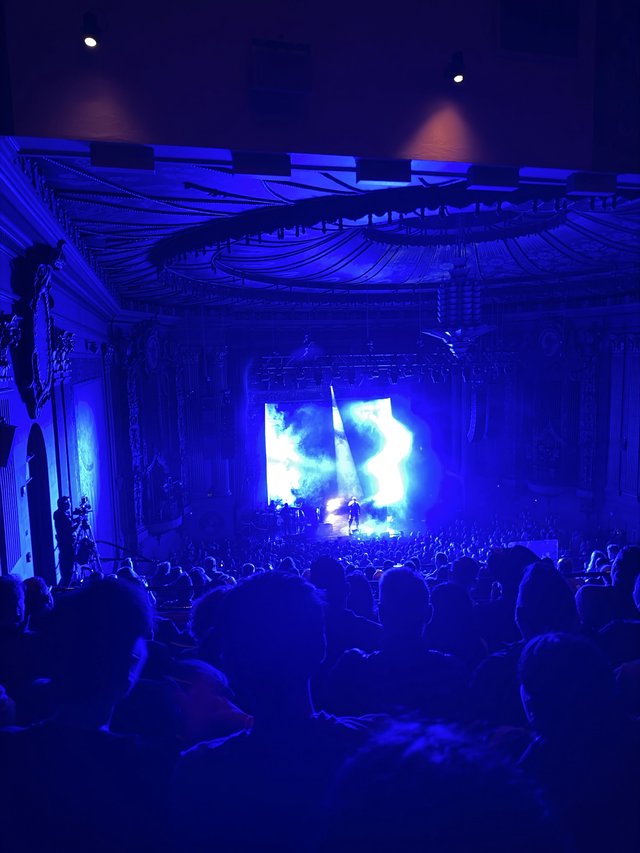 Concert Performance in Historic Ornate Theater with Blue Stage Lighting