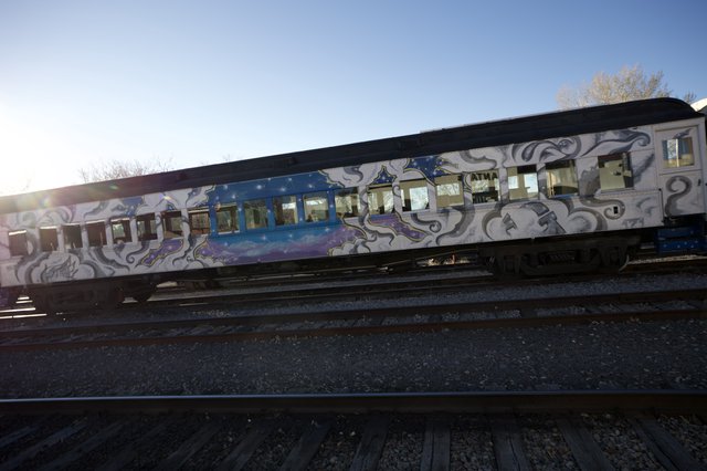 Graffiti-Adorned Train Cars on Railroad Tracks at Sunset