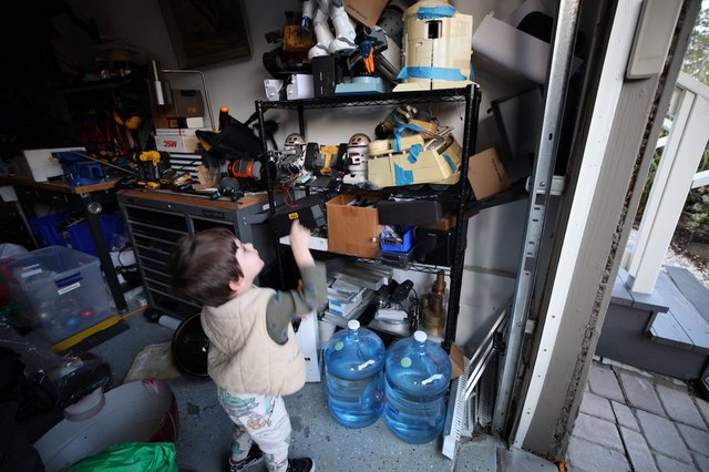Toddler Exploring Cluttered Garage Workshop Storage