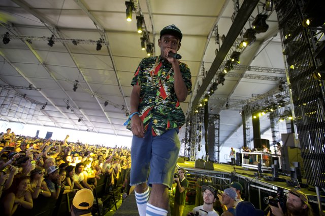 Man on Stage in Tropical Clothes Caption: Tyler, The Creator performs in a colorful shirt and shorts for a crowd of fans at Coachella 2011 on Friday.