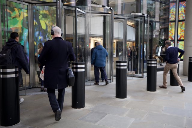 Urban Professionals Navigate Modern Glass Revolving Doors