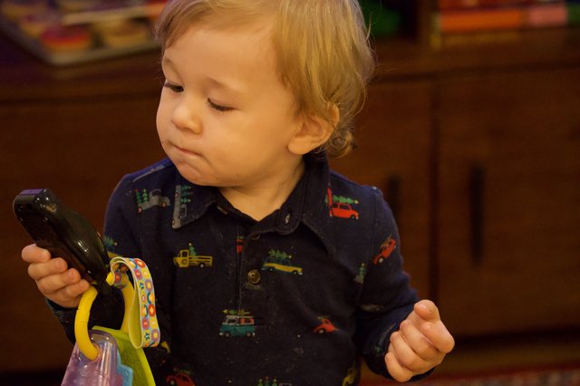 Toddler Examining Dark Green Vegetable with Curiosity