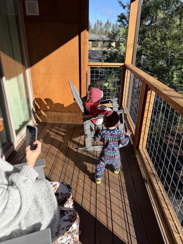 Toddlers Exploring Snowy Mountain Cabin Deck Together
