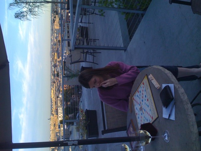 Rooftop Scrabble Game at Dusk Over City Skyline