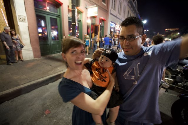 Young Family Celebrates on Austin Street at Night