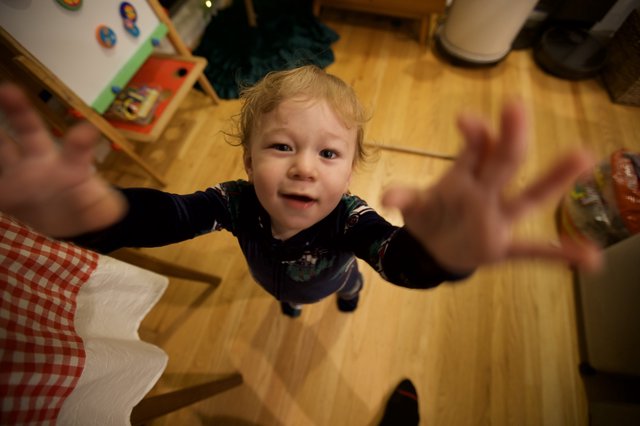 Toddler Reaching Up with Joy on Christmas Morning
