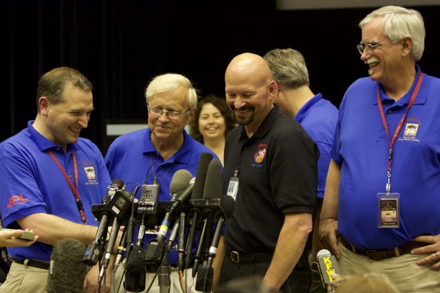 Men in Blue Shirts Address Crowd at Phoenix Press Conference