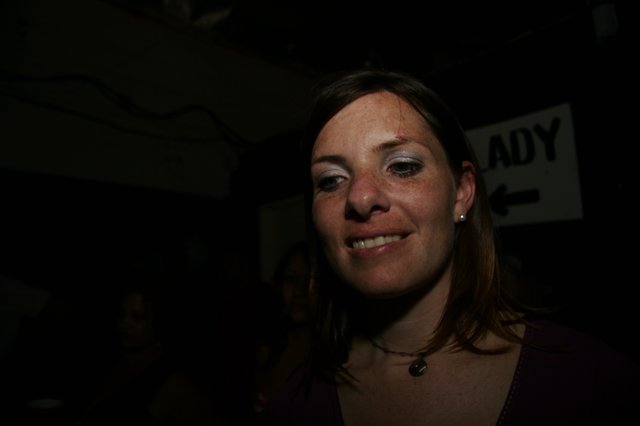 Woman Smiling in Dimly Lit Nightlife Venue