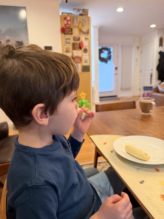 Young Child Enjoying Snack Time at Kitchen Table