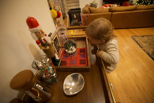 Young Child Examining Christmas Snow Globe Display