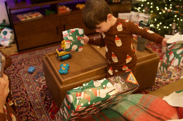 Child Opening Christmas Presents on Holiday Morning