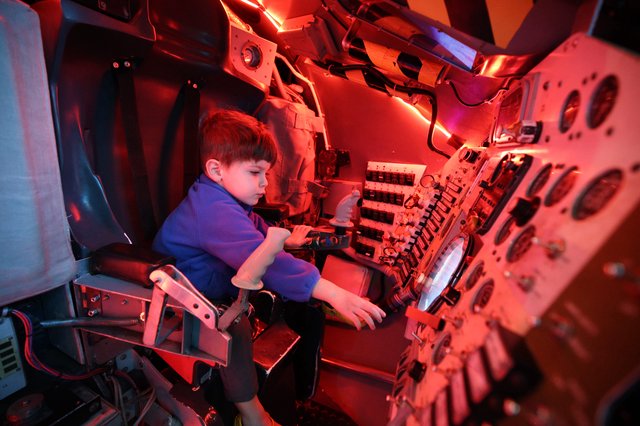 Young Explorer in Submarine Control Room Under Red Light