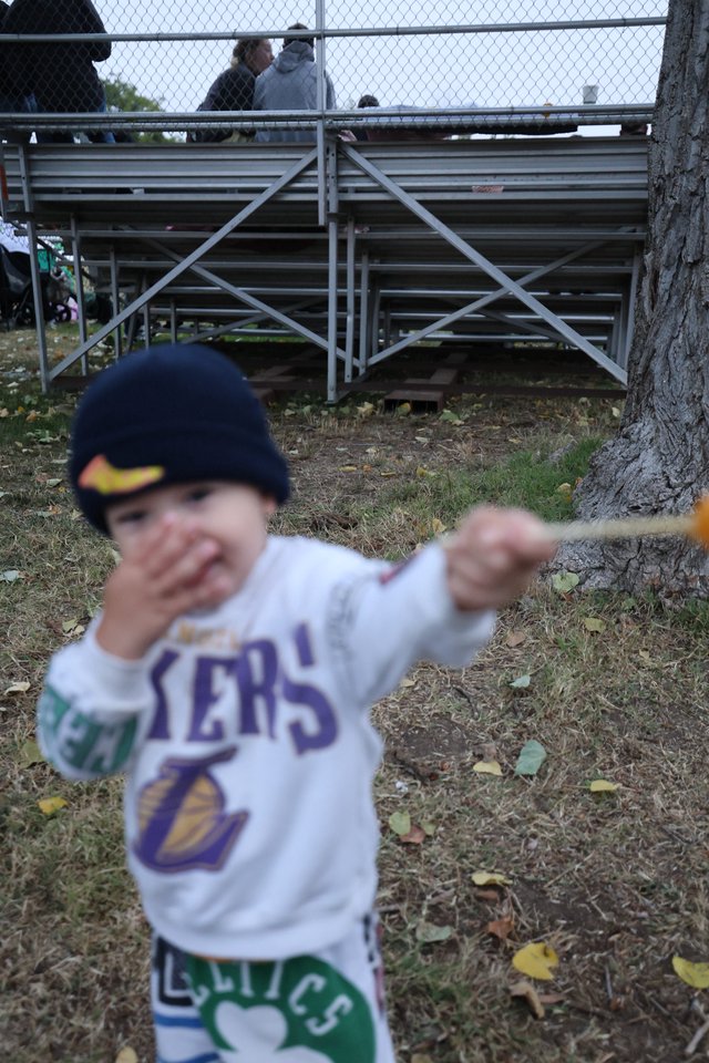 Young Lakers Fan Swings Stick at Autumn Bleachers