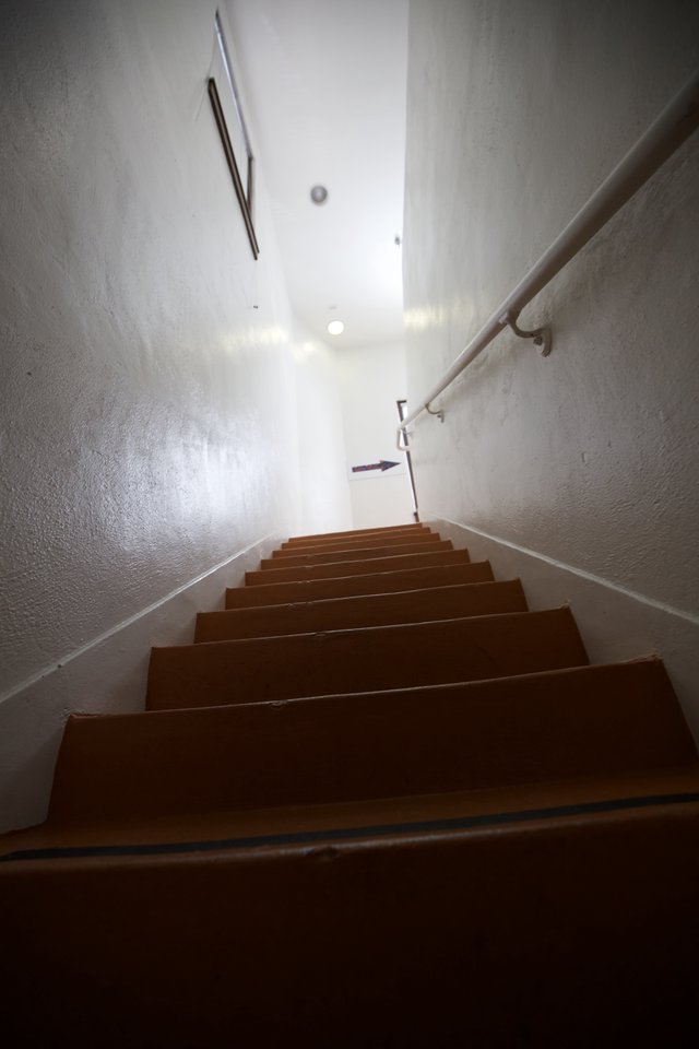 Ascending the Narrow Gallery Staircase in Bright Light