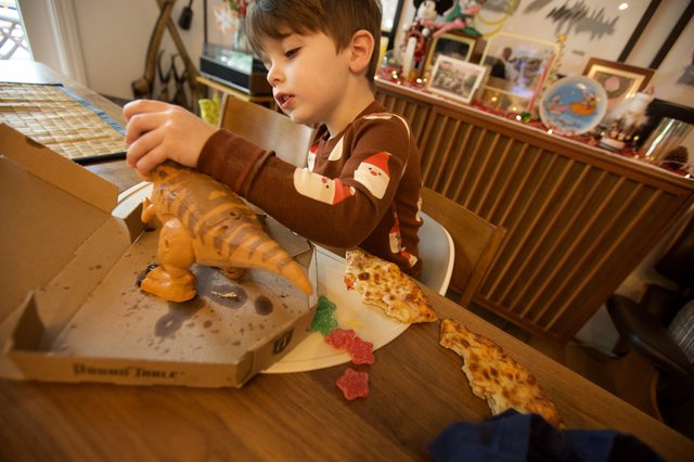 Young Boy Enjoying Pizza on Christmas Day