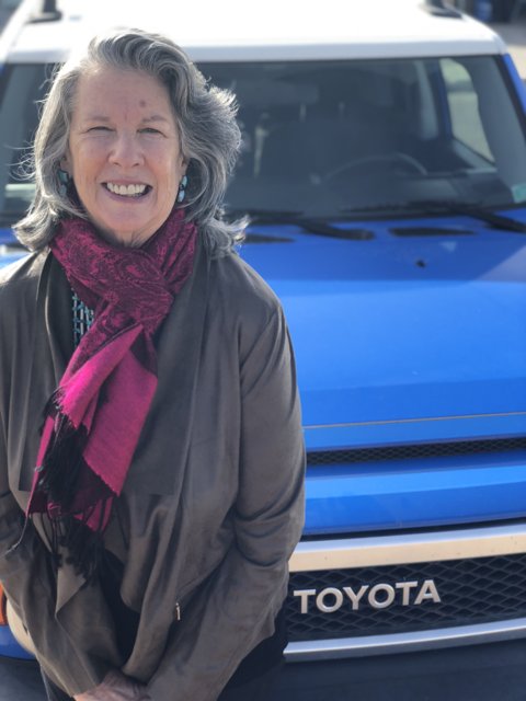 Woman Poses Next to Her Blue Toyota Truck