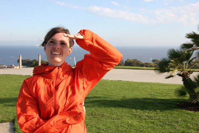 Woman in Orange Jacket Gazes at the Pacific Ocean