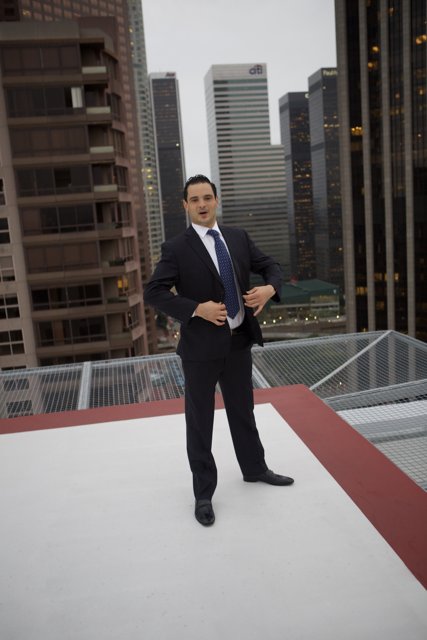 Man in Suit Stands Tall on Skyscraper Roof