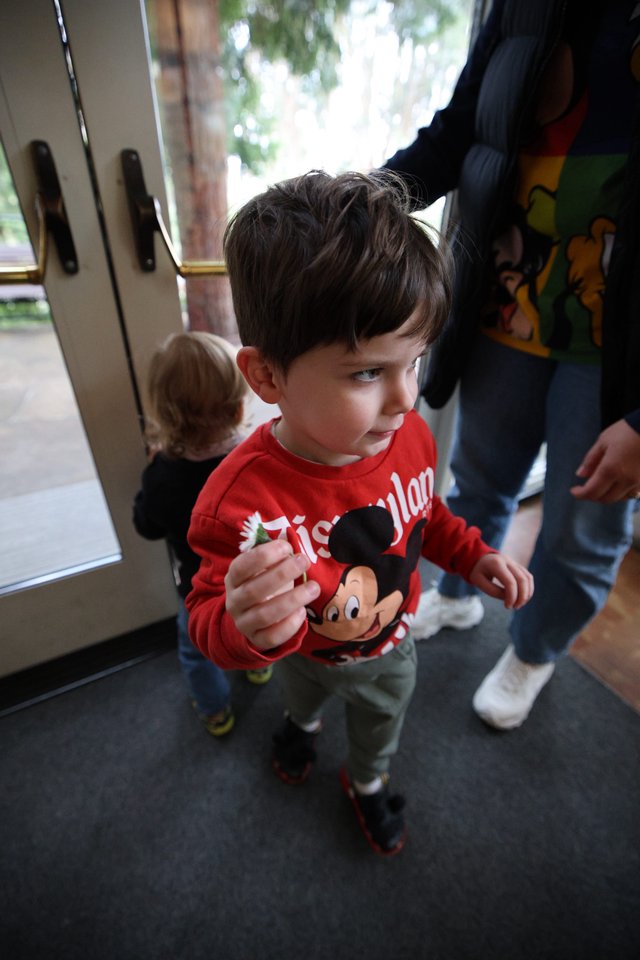 Young Boy with Mickey Mouse Toy at Indoor Gathering