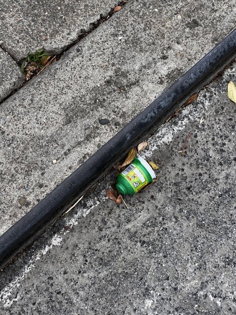 Refreshing Green Drink Abandoned on Sidewalk