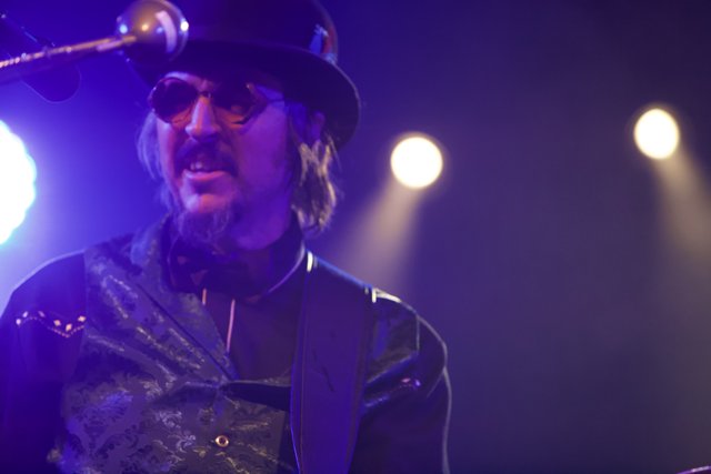 Les Claypool in Top Hat and Bow Tie Rocking the Guitar