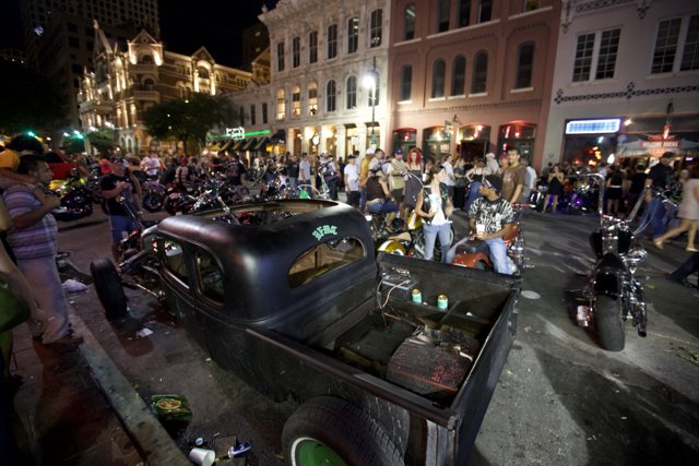 Nighttime Crowd Gathers around Vintage Truck in Metropolis