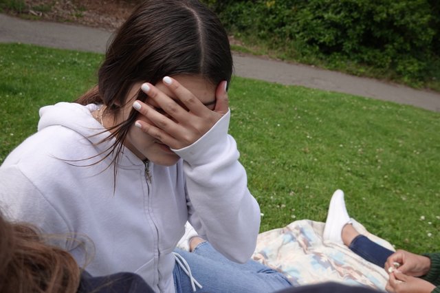 Young Woman Covering Face with Hand Outdoors