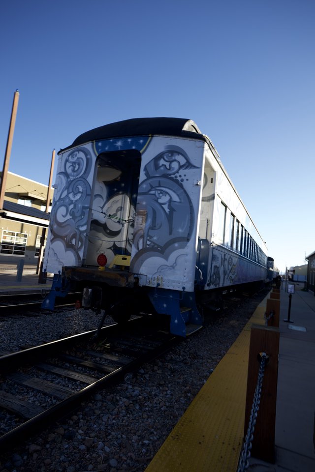 Vintage Train Car with Ornate Blue Artwork at Station