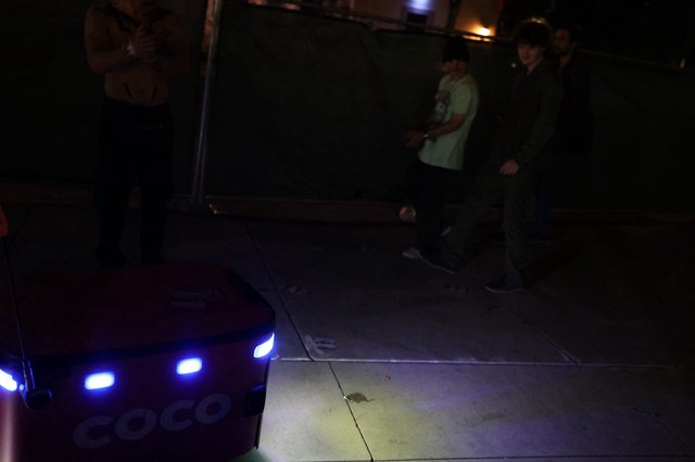 Coco Delivery Robot Navigates Nighttime Festival Crowd