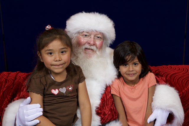 Santa Claus and Two Girls on a Couch