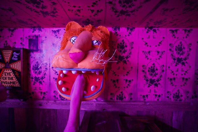 Surreal Puppet Installation in Neon-Lit Room